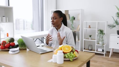 Woman at Desk Talking on Laptop