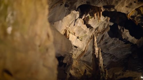 Discover the Stunning and Intricate Cave Formations Within a Dimly Lit Underground Landscape