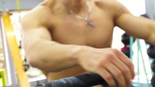 Shirtless Man Exercising on Exercise Machine at Gym