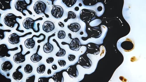 Abstract liquids in swirling patterns mixing in a close-up shot with vibrant contrast and textures