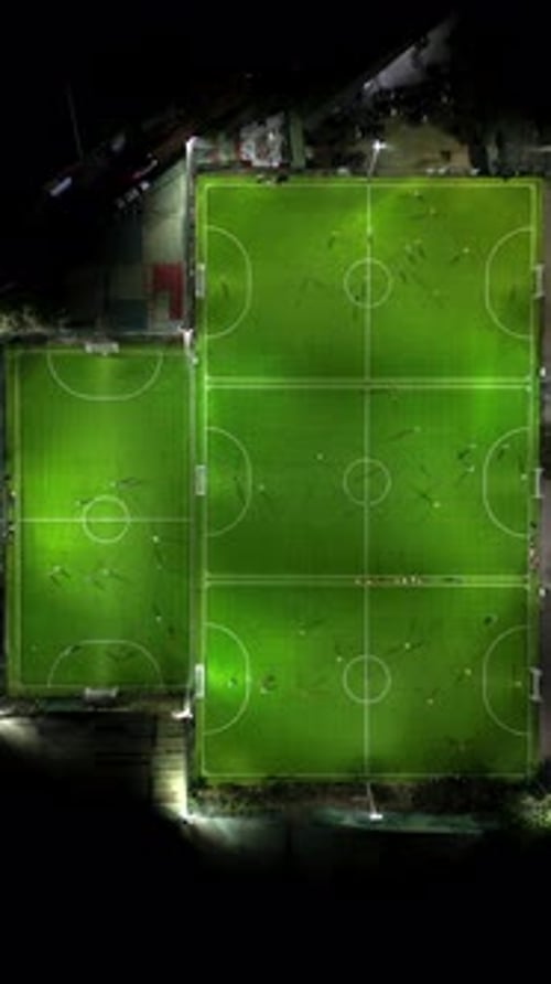 Aerial View of Illuminated Sports Fields at Night