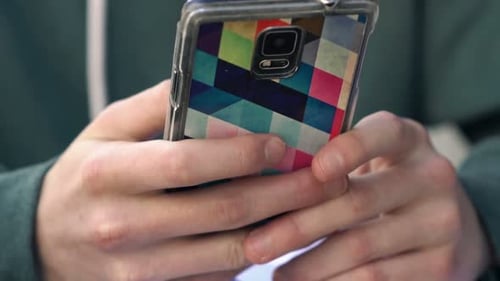 Teenager Texting on Smartphone Sitting in Cafe in City Alone