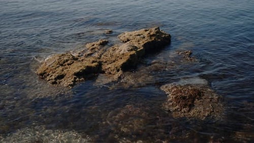 Rock Formations Can Be Seen in Calm Coastal Waters Under a Clear Sky on a Beautiful Day
