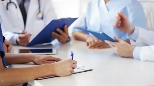 Happy doctors hands hold clipboards and tablet pc at hospital meeting