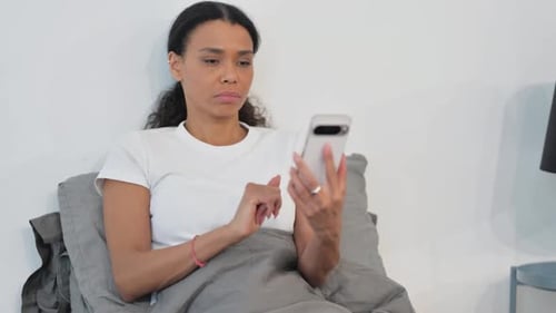 Woman in Bed Using Phone