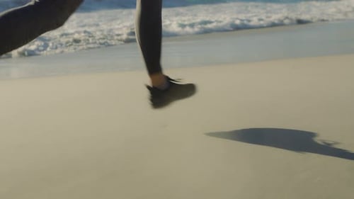 Running, fitness and legs of a woman at the beach, marathon training and cardio on the sand