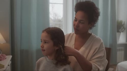 Woman Brushing a Child's Hair at Home