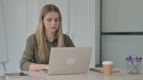Woman Reacts with Shock at Computer in Office