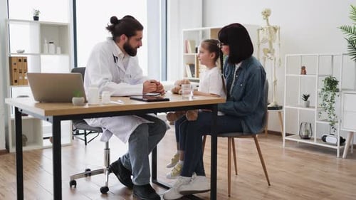 Friendly Doctor Consultation with Mother and Daughter in Clinic Setting