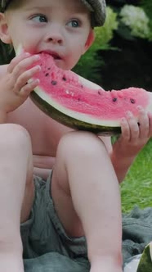 Little Boy Enjoys Watermelon Slice Outdoors