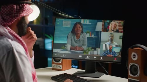 Man Video Conferencing with Colleagues on Computer