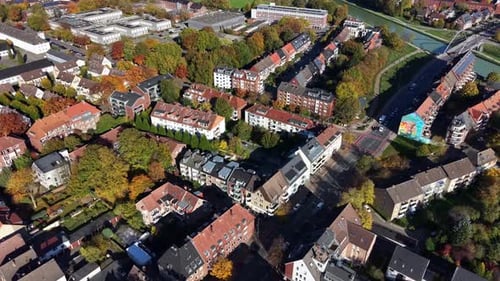 Drone flyover German city with apartment buildings, townhouses and modern university in background.