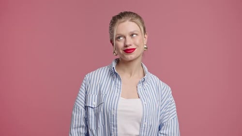 Blonde Woman in Striped Shirt Smiles on Pink Background