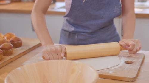Woman Rolling Dough in Sunny Kitchen