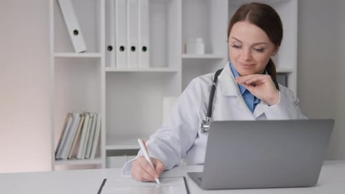 Woman Doctor Working at Desk with Laptop