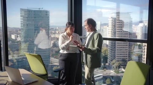 Businesspeople Discussing Strategy on Tablet in Modern Office