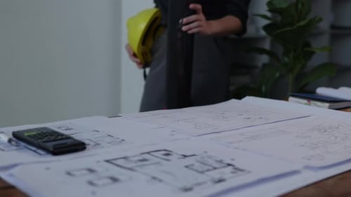 Architect Reviewing Blueprints in Office Setting