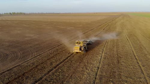 Aerial View of Tractor Plowing Field with Disc Plow Trailer