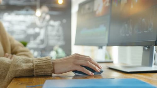 In der Kreativagentur Nahaufnahme der Hand einer Frau, die die Maus benutzt und auf ihrem PC tippt