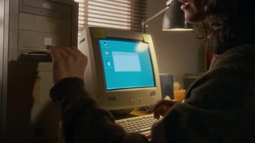Frau legt Diskette in alten Computer ein, um eine Dokumentdatei zu speichern