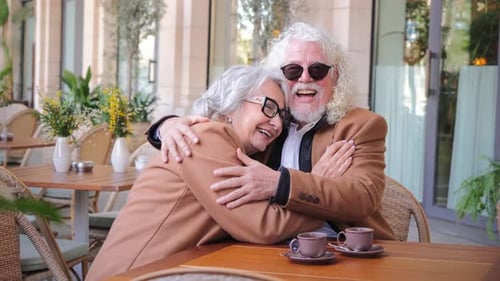 Affectionate Senior Couple Embracing at Outdoor Cafe