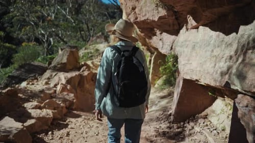 Abgeschiedener Backpacker schreitet auf einem schmalen Pfad inmitten natürlicher Sandsteinformationen und Ruhe