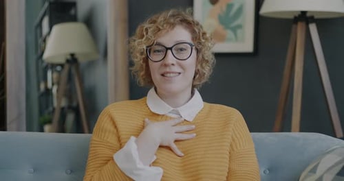 Woman Waving and Talking to Camera Indoors