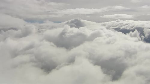 helicóptero fotografado acima de grandes formações de nuvens brancas fofas