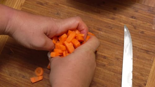 Chopped Carrots Poured Into Bowl on Wooden Board