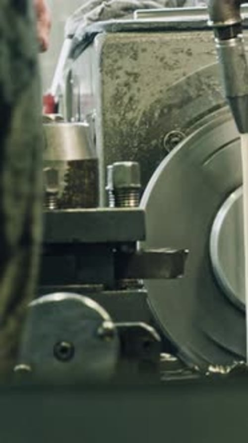 Metal worker using lathe machine in industrial workshop
