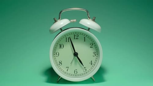 The alarm clock on a green background, in the style of time-lapse video.