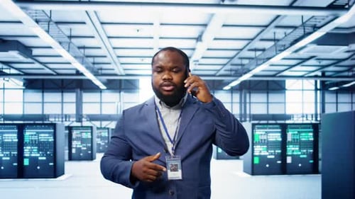 IT Technician Talking on Phone in Data Center Coordinating Server Maintenance