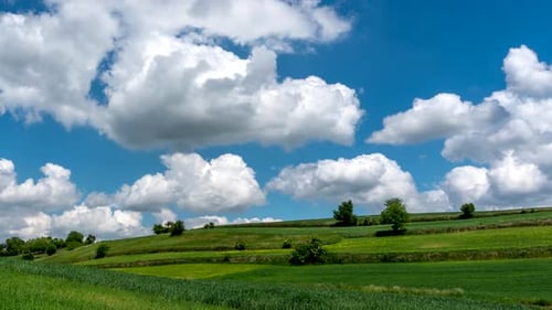 Dramatic Clouds over Green Fields Time Lapse