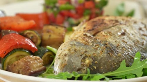 Whole Cooked Fish with Roasted Vegetables on Plate