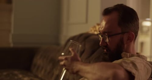 Man Sitting on Couch Drinking Wine