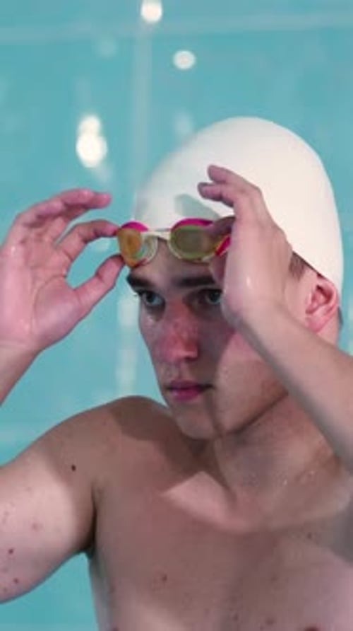 Swimmer Adjusts Goggles Before Entering Pool