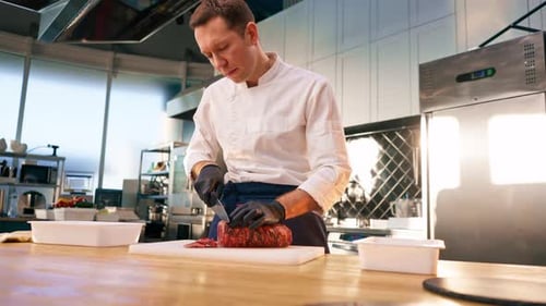 Chef Slices Prepared Meat in a Professional Kitchen