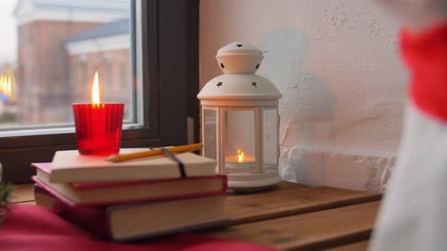 Festive Candle and Books on Window Table