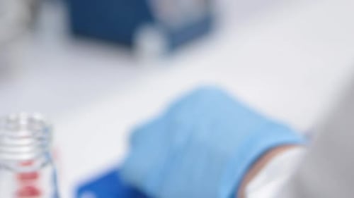 Detail einer wissenschaftlichen Hand bei der Durchführung eines Tests in einer Wanne in einem Labor mit weichem Fokus