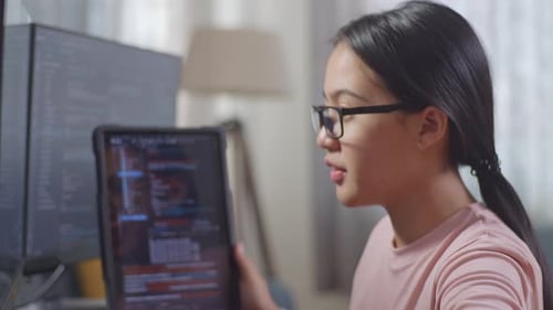 Une programmeuse adolescente regarde une base de données sur une tablette tout en créant une application de développement d'une Appli d'ingénieur logiciel