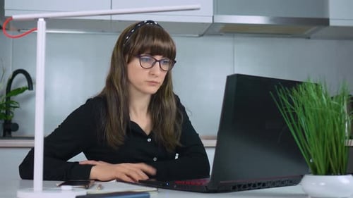 Empresária focada trabalhando em um laptop no escritório doméstico