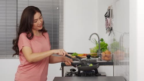 Woman Cooking and Stirring Food in Kitchen