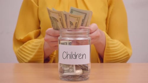 Woman Puts Money in Jar Labeled Children