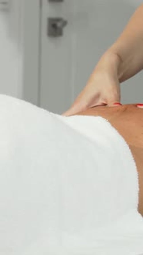 Woman Receives Shoulder Massage in Bright Spa