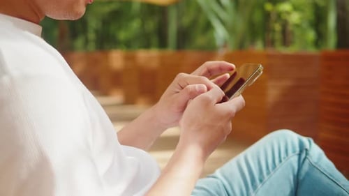 Person Typing on Gold Mobile Phone Outdoors