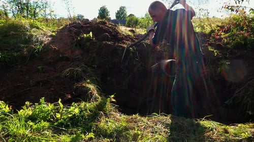 Man Digging a Hole with a Shovel Outdoors