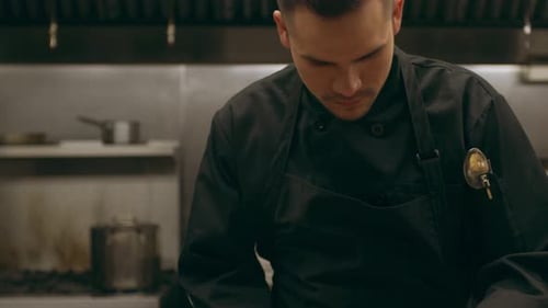 Chef Seasoning Fresh Salmon Fillets in Professional Kitchen