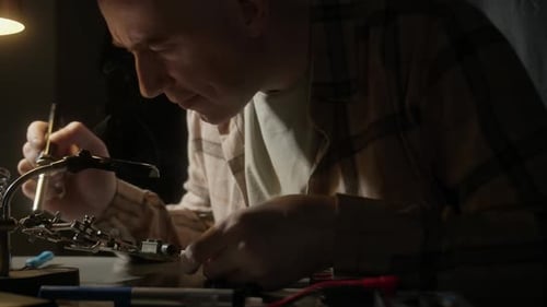 Man Soldering Small Piece of Hardware