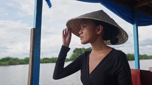 Woman in Conical Hat on Tropical River Boat