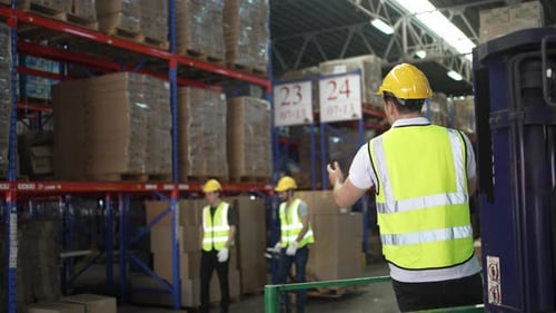 Blue collar workers are working at warehouse.